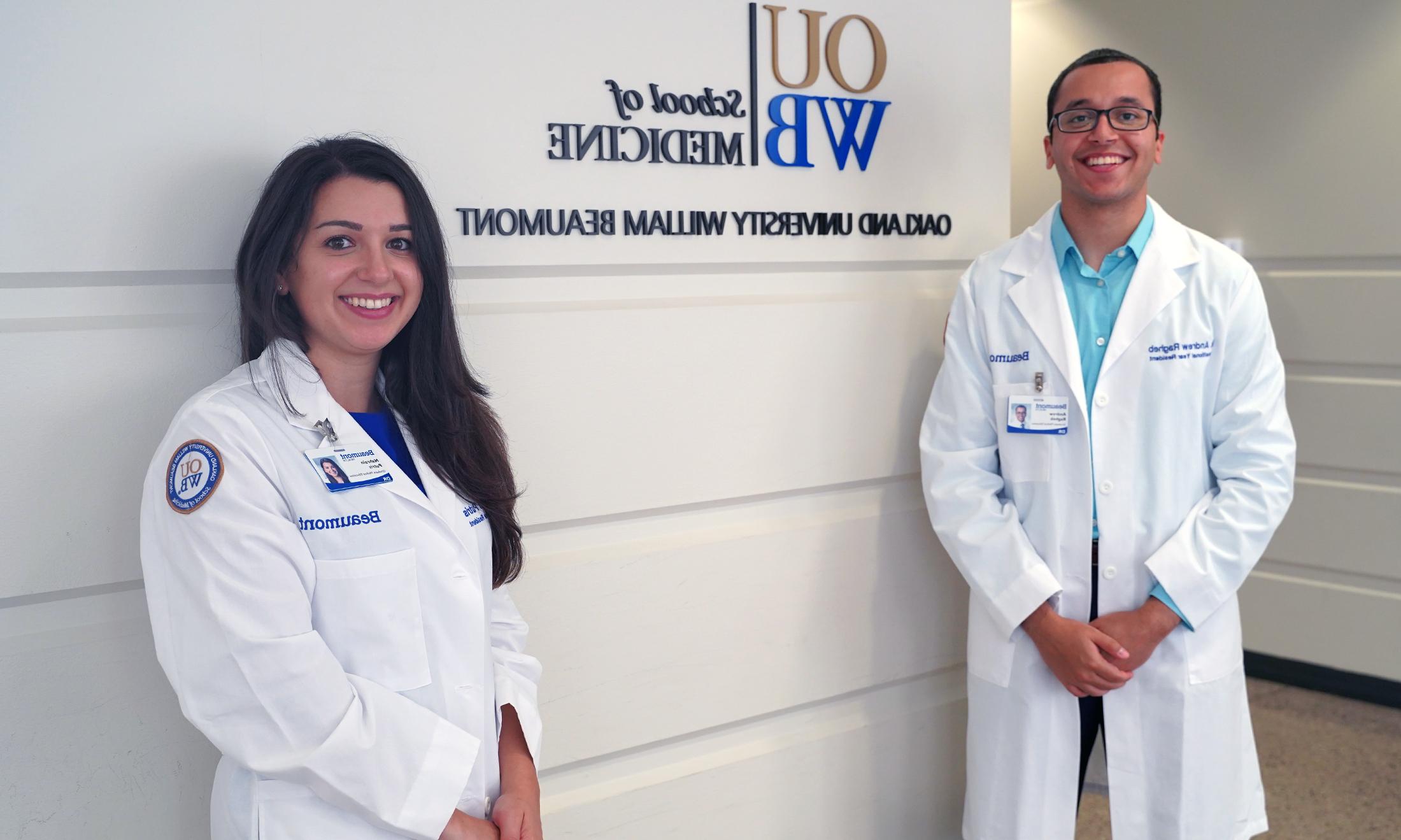 An image of OUWB alumni posing in front of an OUWB sign.